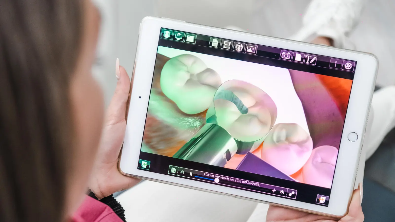 Patientin betrachtet die Darstellung ihrer Zähne auf einem Tablet
